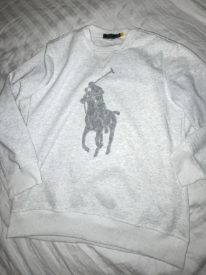  sweatshirt från Polo Ralph Lauren - Sweatshirt från Polo Ralph Lauren med stort grått polospel-tryck på bröstet. Helt ny. S/M. Ej orginal. 260kr färdig prutat o klart!