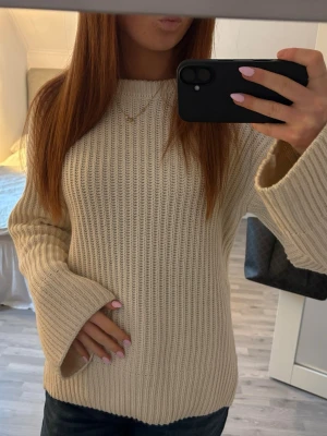 Beige stickad tröja med vida ärmar - Säljer en beige stickad tröja med breda, vida ärmar och grov ribbstickning. Tröjan har en rak passform och rund halsringning. Knappt använd!! Jättebra skick! Storlek XS men passar mer S