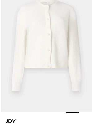 Vit stickad kofta från JDY - Säljer en stilren vit stickad kofta från JDY med rund hals och vita pärlor fram till, säljer då den inte kommer till användning längre men den är i fint skick!