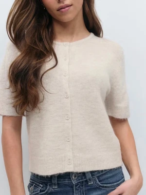 Beige kortärmad kofta från Gina Tricot  - Använd en gång. Supermjuk och fluffig beige kofta från Gina Tricot med korta ärmar och rund hals. Koftan har knappar framtill och ribbade kanter vid ärmslut och nederkant. Perfekt att styla med jeans eller kjol för en chill look. Storleken är 170, slutsåld i alla storlekar på hemsidan. Denna storlek passar mig som vanligtvis använder M/S. 