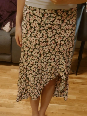 Blommig kjol  - Jättefin och blommig kjol, perfekt för att ha på stranden. Den har en snygg slits och är i ett tunt tyg som inte är genomskinligt. Passar ca storlek S-XS 