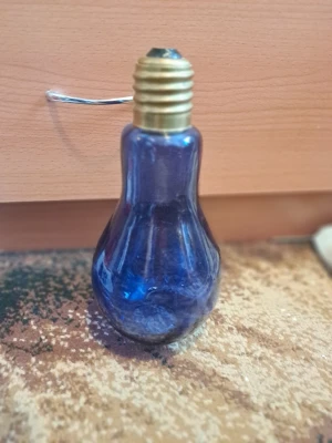 Dekorativ blå lampa i Glas - Säljes: En unik och dekorativ lampa formad som en glödlampa. Den är tillverkad av blått glas och har en metallbas som liknar en traditionell glödlampssockel. Perfekt som en inredningsdetalj eller som en stämningsfull ljuskälla. På bild 3 visar det defekter med lite missfärgningar.   Vid övriga frågor skicka gärna meddelande.  Lämnar självklart god omdömen om köparen gör det.  Ingen återköp eller retur om köparen går med på köpet.  Kolla gärna in mina annonser! 