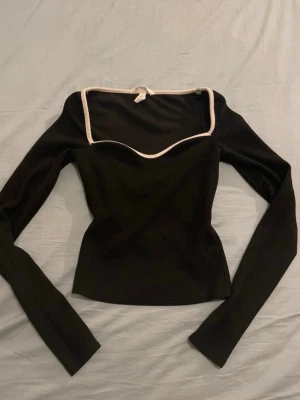 Svart långärmad topp med vit kant - Superfin svart långärmad topp med vit kant! Storlek xs och i fint skick🥰🥰💞💞 säljer då den är för liten för mig!!