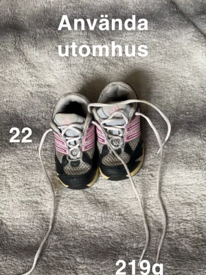 Adidas sneakers barn strl 22 - Säljer ett par Adidas sneakers för barn i storlek 22. Skorna är grå med svarta och rosa detaljer, har klassiska ränder på sidan och vit snörning. Ovandelen är i mesh och syntet för bra ventilation och komfort. Perfekta för aktiva dagar utomhus!🌸 Använt skick. Ej tvättade. Stl 22