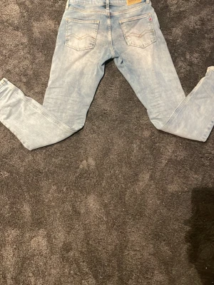 Replay ljusblå jeans straight fit - Säljer ett par ljusblå jeans från Replay med klassisk femficksdesign och raka ben. Jeansen har snygga detaljer på bakfickorna och ett Replay-märke i läder baktill. Tillverkade i jeansmaterial med kontrastsömmar och normal passform. Ställ så mycket frågor ni vill 🌟