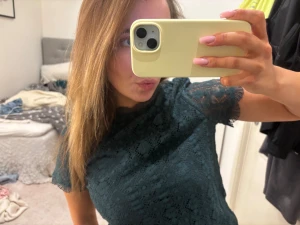 Mörkgrön spetsblus med kort ärm -  mörkgrön blus i spets med korta ärmar och rund hals i strl S. 