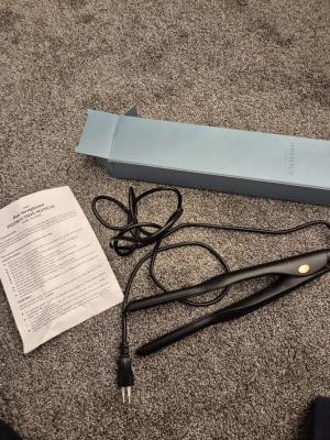 Svart plattång från Dahlbergs - Säljer en svart plattång från Dahlbergs Scandinavia med digital display och enkel knapp för på/av. Slät och stilren design med guldaccent. Kommer med originalförpackning och instruktionsmanual. Perfekt för att styla håret snabbt och smidigt.