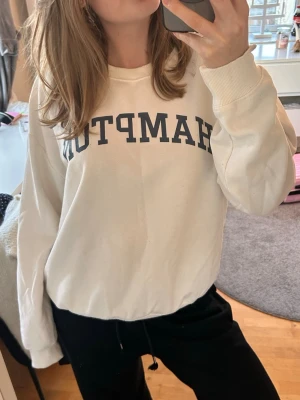 Sweatshirt  - Säljer en vit sweatshirt med texten ”HAMPTON”. Storlek M. Använd fåtal gånger och är i acceptabelt skick. Skriv om du har frågor! 💖
