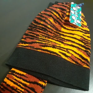 Kenzo mössa med tigerinspirerat mönster - Snygg mössa från Kenzo med tigerinspirerat mönster i röd, orange och svart. Mössan har bred svart ribbad kant och är tillverkad i mjukt stickat material. Perfekt för dig som vill sticka ut med en djärv accessoar.