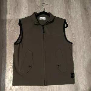 Stone Island väst - Tjena säljer nu denna riktigt snygga västen från Stone Island pågrund av att den börjar bli för liten för mig, från axlarna till midjan är den 60 cm och från ena sidan midjan till andra sidan midjan är den 50 cm så jag skulle klassa den som en XS fast det står junior/170 tveka inte på att höra av er Mvh Algot