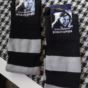 2 Par Randiga knästrumpor Stl 40/42 - Helt nya. 2 par knästrumpor från Sockcompagniet i svart och silver. Kan hämtas i Norra Stockholm. 