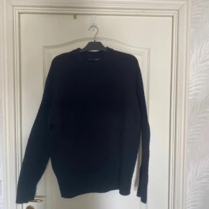 Svart stickad tröja - En svart stickad tröja från Lager 157. Den är väldigt nopprig men inga hål som jag kan hitta. 