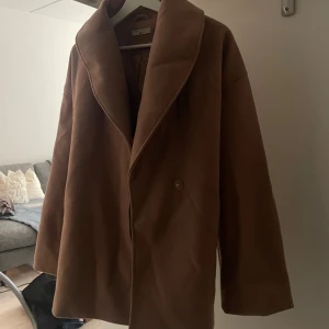 brun kappa - säljer denna jättefina kappan från ginatricot, fint skick, nopprig på vissa ställen men inget man lägger märke till☺️ älskar att den har band som går att knyta antingen bakom eller framtill!💕🍂