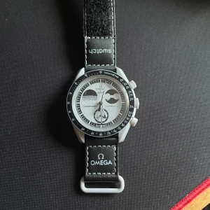 Omega x Swatch Speedmaster Moonwatch - Säljer en Omega x Swatch Speedmaster Moonwatch Mission to the Moon. Klockan är antagligen inte äkta eftersom jag fick den av en kompis. Ibland måste man trycka på knappen för att klockan ska fortsätta gå. Säljs därför till det billiga priset