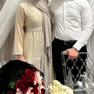 Champagnefärgad långklänning med pärldetaljer - Säljer en marockansk klänning som endast har använts en gång. Den är i storlek M men passar även S. Nypriset var ca 2000 kr.