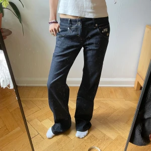 Mörkblå jeans från G-Star RAW - Mörkblå jeans från G-Star RAW med låg midja och raka ben. W26 L32