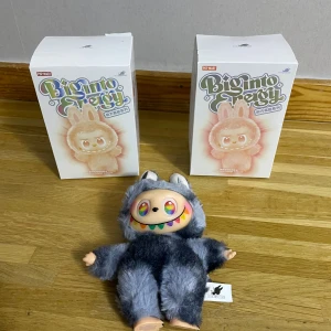 Pop Mart Big Into Energy Plush Figure - Samlarfigur från Pop Mart Big Into Energy-serien. Söt och färgglad plush-figur med regnbågsfärgade ögon och mjuk pälsdräkt. Levereras med originalförpackning. Perfekt skick, inga synliga defekter eller slitage. Passar samlare och dekorationsentusiaster.