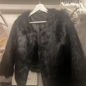 Svart kortärmad pälsjacka  - Säljer en svart pälsjacka från Aisui med kortärmad design och glansig finish. Jackan är kortärmad och knappt använd, köpt för 450kr säljer för 300 |skriv vid intresse💕 