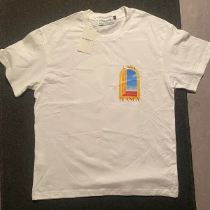 Casablanca t-shirt - Vit t-shirt från Casablanca med färgglad grafisk print i gult, blått och rött både fram och bak. Klassisk passform, rund hals och korta ärmar. Tillverkad i mjuk bomull och har en stilren vibe med tydlig logga och konstnärlig design.