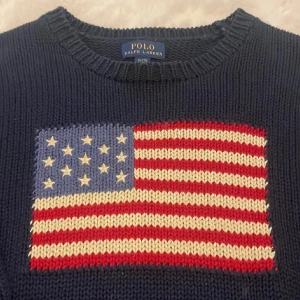 Mörkblå stickad tröja Polo Ralph Lauren - Köpt för 1000kr Mörkblå stickad tröja från Polo Ralph Lauren med amerikansk flagga broderad på bröstet och RL-broderi vid nederkanten. Klassisk rund halsringning och långa ärmar. Perfekt för dig som gillar preppy stil och vill sticka ut. Modellen 16år!! Sitter som en S ❤️