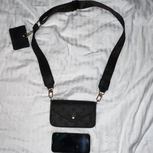 liten svart väska - liten axelremsväska med tillhörande korthållare. passar en iphone13?