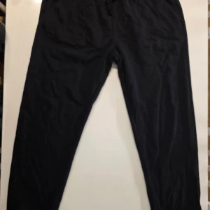 Svarta mjukisbyxor från H&M - Svarta mjukisbyxor från H&M i regular fit, storlek L. Byxorna har resår i midjan och är tillverkade i en mjuk blandning av bomull och polyester. Perfekta för chill dagar eller när du vill ha det extra bekvämt.         Jättesköna de som har provat H&Ms byxor vet det