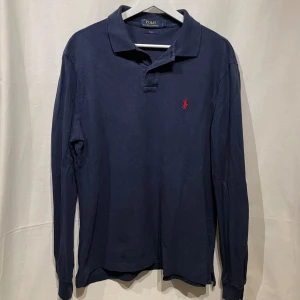 Långärmad Ralph Lauren pike - sjukt snygg marin blå pike från RalphLauren. Storlek L men passar M, modellen är 180cm