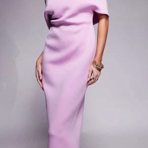 Ljuslila långklänning med kort ärm - Elegant ljuslila/rosa långklänning med mjuk, figurnära passform och kort ärm. Klänningen är helt ny med prislapp på. 