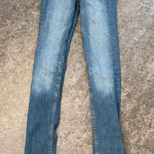 Blå skinny jeans från Cubus, 25/32 - Snygga blå skinny jeans från Cubus med hög midja. Klassisk denimlook med ljusare tvätt längs benen och smal passform hela vägen ner. Perfekta för dig som gillar en tight och modern stil.