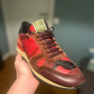 Valentino Rockrunner sneakers röd/brun - Säljer ett par röda Valentino Rockrunner sneakers. Köpta här på plick från Trendsellers AB. Tyvärr lite för stora för mig, därav säljer jag skorna. Enbart skorna tillkommer. Skick: 7/10