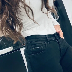 Svarta skinny jeans från Calvin Klein - Säljer ett par svarta skinny jeans från Calvin Klein Jeans. De har hög midja, klassiska fem fickor och diskret logga på fickan fram. Jeansen är i stretchigt jeansmaterial och sitter tight hela vägen ner. Perfekta för dig som gillar en clean och stilren look.