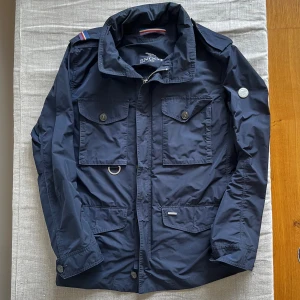 Snoot fieldjacka - Riktigt snygg fieldjacka från snoot i storlek M. Jackan är i fint skick och är perfekt till hösten.  Nypriset ligger på 3800 kr. På jackan finns även en uppfällbar luva (bild 3). Hör av er vid frågor!