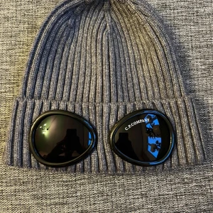 Grå C.P. Company Mössa - Dem är frescha och icke skadad samt inga fläckar. Vid mer frågor är det bara att skriva!