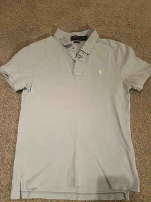 Polo Ralph Lauren Pike  - Tjena, säljer denna ljus blåa pikén från Polo Ralph Lauren. Mycket bra skick. Storlek 14-16 år. Hör av er vid funderingar eller intresse🤩