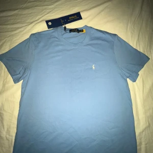 Ralph Lauren T-shirt  - Ralph Lauren T-shirt i blå, oanvänd, storlek M, ny med prislapp, äktahetsbevis: Qr kod
