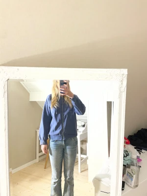 Blå zip-up hoddie från Gina Tricot - Mysig blå zip-up hoddie från Gina Tricot i storlek S. Hoddien har dragkedja framtill, ribbade muddar och är tillverkad i en blandning av bomull och polyester. Perfekt för kyliga dagar när du vill ha något bekvämt och stilrent.