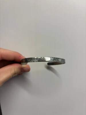 Handgjort hamrat silverarmband - Stilrent armband i silverfärgad metall med hamrad yta som ger en rå och unik känsla. Öppen design som gör det enkelt att ta på och av. Perfekt accessoar för dig som gillar minimalistisk och modern stil. Snabb frakt. Hör av dig vid frågor! 