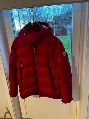 Moncler pufferjacka med huva - Säljer min äkta röd pufferjacka från Moncler med stor huva och ribbad krage. Storlek 4 (passar unisex M-L) Kvitto och orginalförpackning följer med. Köpt för 14 100 kr. Hör av dig om du har några frågor! 