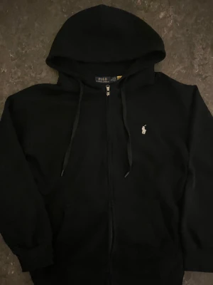 Svart hoodie från Polo Ralph Lauren - Svart hoodie från Polo Ralph Lauren. För liten för mig men den är i mycket bra skick. Priset kan diskuteras vid snabb affär!