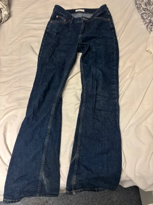 Flared/straight mörkblå jeans från Gina - Storlek 34 från Gina Tricot. Midjemåttet är 33 cm och innerbenslängden är 72cm. Dessa är inte low waist utan snarare mid eller high waist! 