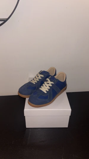 Blå sneakers från Maison Margiela - Blå Maison Margielas i storlek 43. Det är mycket bra skick på dom låda och påse med kommer men har ej kvitto därför är priset så lågt. 