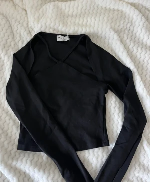 Svart festtopp från NA-KD - Festtopp från NaKd med snygg detalj där fram! Använd fåtal gånger 🩷 