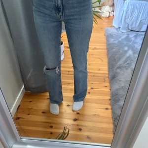 Blå bootcut jeans från Gina tricot  perfect jeans - Säljer ett par blå bootcut jeans från g perfect jeans i storlek 32. Jeansen har hög midja, med hål på ena knät.