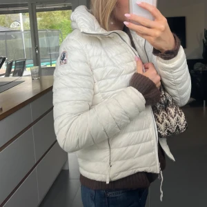Vit dunjacka från Parajumpers - Säljer en snygg tunn vit dunjacka från Parajumpers med quiltad design. Dragkedja fram och bak, krage som går att göra högre och två fickor. Clean jacka!!! Använd försiktigt och i bra skick!!!
