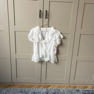 Oanvänd vit volangblus från Nelly!💓💓 - Jätte skön och snygg vit blus ifrån Nelly, helt ny och prislapp sitter kvar!💞