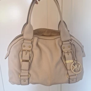 Michael kors väska - Jättefin väska från michael kors med guld detaljer. Väskan har många fack