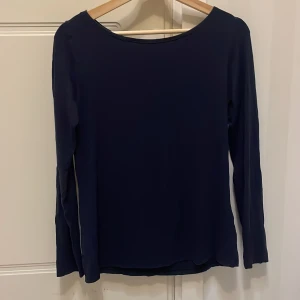 Mörkblå långärmad topp Intimissimi - En stilren mörkblå långärmad topp från Intimissimi. Toppens enkla design gör den lätt att matcha och den har en rundad halsringning. Materialet känns mjukt och följsamt mot huden, perfekt för dig som gillar en clean och klassisk look. Säljer då den är för stor, annars jättefin mörkblå tröja i lite tjockare material. Den är inte jätte genomskinlig.