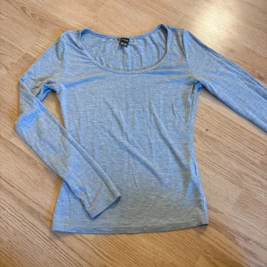 Ljusgrå långärmad topp från SHEIN - En basic ljusgrå långärmad topp från SHEIN i supermjuk bomullsblandning. Modellen har rundad halsringning och en slim passform som sitter snyggt på kroppen. Perfekt att styla med jeans eller kjol för en enkel och clean look.