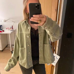 Grön jeansjacka från zara  - Säljer en oversized ljusgrön overshirt i jeansmaterial med stora fickor framtill och knappar hela vägen. Jackan har en avslappnad passform och långa ärmar, perfekt att slänga över en t-shirt eller hoodie för en chill och trendig look. Har kommit till användning väldigt mycket då jag tycker den är jättefin!🥰🥰 