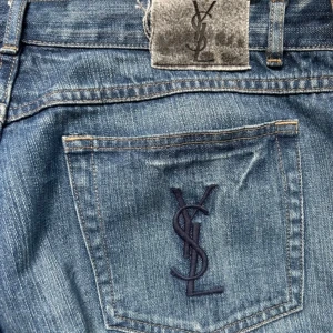 Yves Saint Laurent jeans - Blå straight fit jeans från Yves Saint Laurent med klassisk straight fit och normal passform. Snyggt YSL-broderi på bakfickan. Jeansen är i storlek 36/34 men sitter mer som 34/34. Hör av er om ni har frågor.